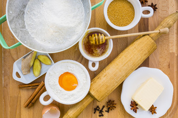 Ingredients to make Christmas gingerbread on wooden background.