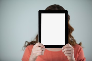 Woman holding a digital tablet in front of her face