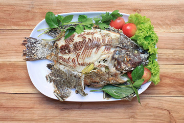Tilapia fish grilled with Salt in white dish.