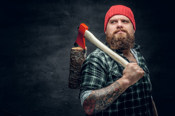 Lumberjack dressed in a green shirt holds the red axe.