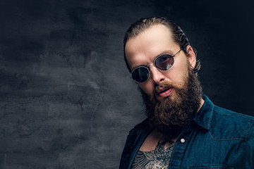 Obraz premium Bearded male in sunglasses with tattoo on his chest.