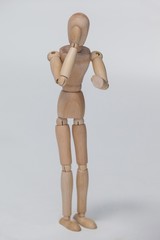 Wooden figurine standing and pretending to talk on phone
