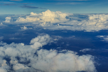 Fototapeta na wymiar 飛行機の窓から見える 雲　青空　陸　