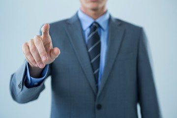 Mid section of businessman touching an invisible screen