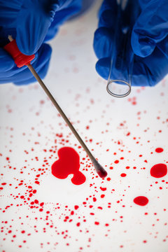 Forensic technician taking DNA sample from blood stain