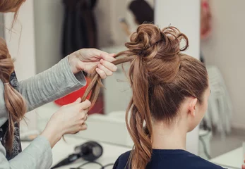 Photo sur Plexiglas Salon de coiffure High Hairstyle creating process in hairdresser salon with elegant bun. Blonde and red hairs