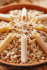Raw whole wheat pasta and wheat close up