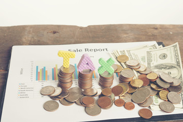 Tax Concept with wooden block on stacked coins