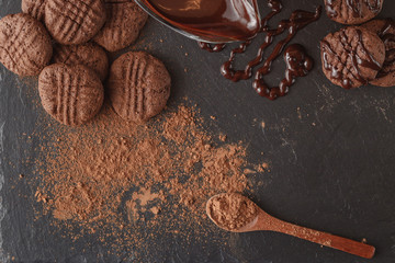 Chocolate with cocoa powder in the spoon. On the stone table