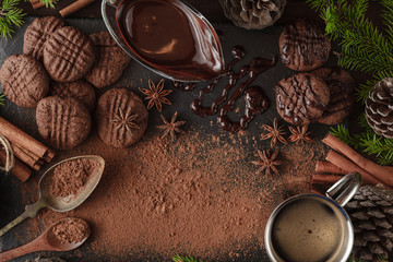 Broken chocolate bar and spices on stone board
