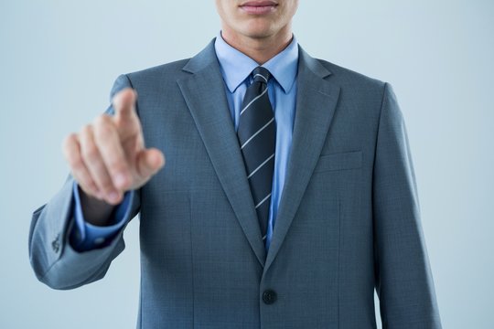 Mid section of businessman touching an invisible screen