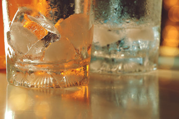 empty glass with ice on counter bar in night club