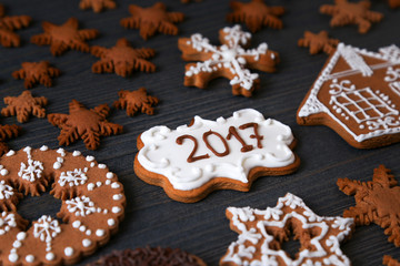 Obraz na płótnie Canvas Xmas cookies in a different shape of snowflakes with 2017 numbers on a dark wooden background. 
