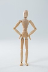 Wooden figurine standing with hands on hip