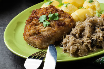 Fried pork schnitzel served with boiled potatoes and fried sauer