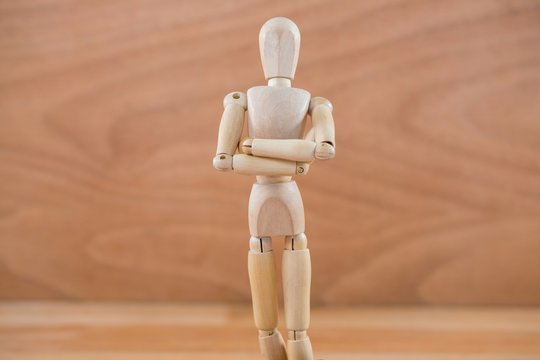 Wooden figurine standing with arms crossed