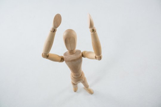 Wooden figurine standing with hand raised