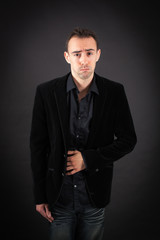 Handsome man doing different expressions in different sets of clothes: stomachache