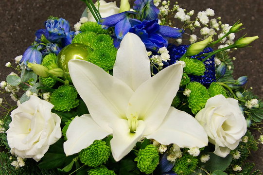 Close up christmas decoration with spruce branch, white lily, rose and blue bells 