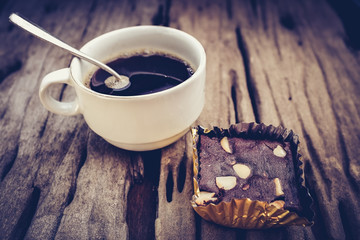 Cake chocolate brownie and hot coffee on old wooden background.