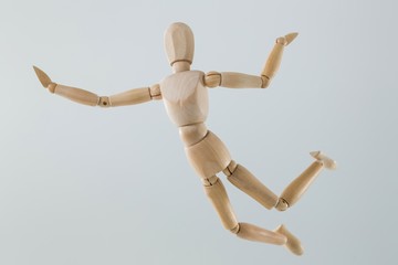 Wooden figurine jumping in the air