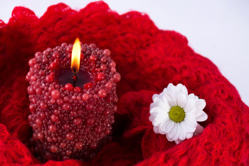 Burning candle. Chamomile. Red scarf