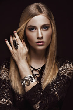 Beautiful blond woman with healthy skin and hair, red manicure, posing in studio. Beauty face