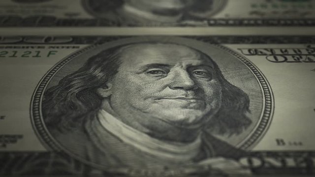 Hundred Dollar Bill Uncut (24fps). Camera moves along an uncut crisp sheet of U.S. $100 bills, freshly minted from a printing press.