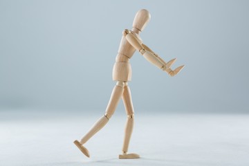 Wooden figurine pretending to push an invisible object