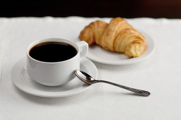 A cup of coffee and a croissant. Festive breakfast Valentine's Day with love letters.