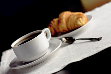 A cup of coffee and a croissant. Festive breakfast Valentine's Day with love letters.