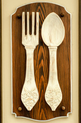 fork and spoon carved from a tree on a background of the old city. Handmade wood.