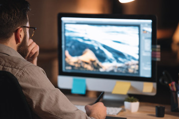 Handsome bearded web designer working with computer late at night