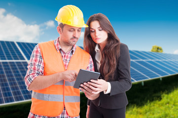 Young architect and elegant female browsing on tablet