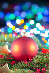 Fototapeta na wymiar Red Christmas ball, spruce tree and ornaments