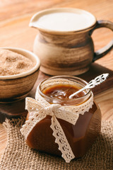 Fototapeta na wymiar Caramel sauce on brown wooden background. 