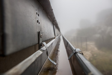 Gutter drainage system on the roof with dripping fog