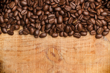 Granos de café sobre tabla de madera. Vista superior. Copy space