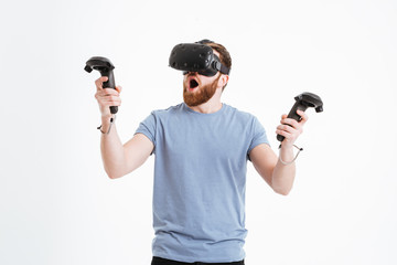 Surprised bearded young man wearing virtual reality device