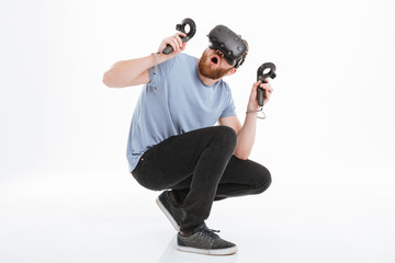 Scared bearded man wearing virtual reality device