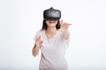 Young cheerful lady wearing virtual reality device