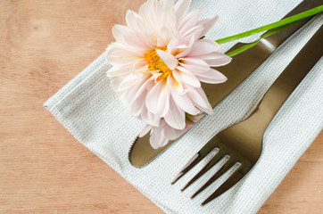 Spring table settings with fresh flower, napkin and silverware.