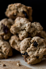 Cookies with raisin and hazelnut stacked up on wooden surface..