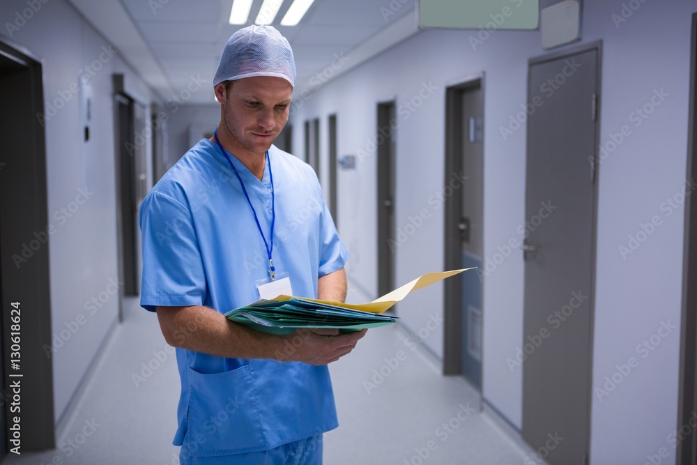 Poster Surgeon checking report in corridor
