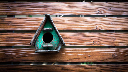 cute little birdhouse on wooden fence