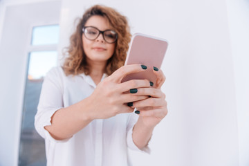 Fototapeta premium From below image of Woman in shirt making selfie