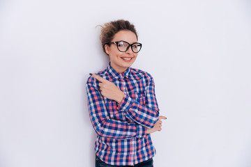Woman in checkered shirt pointing away