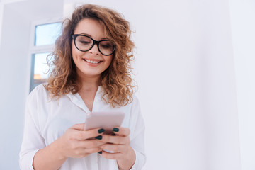 Smiling Woman in shirt writing message on phone