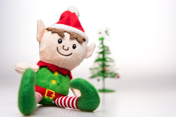 Little elf handmade toy christmas decoration with christmas tree on white background