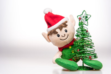 Little elf handmade toy christmas decoration with christmas tree on white background